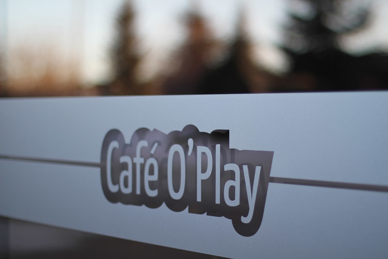 a window with Cafe O Play logo