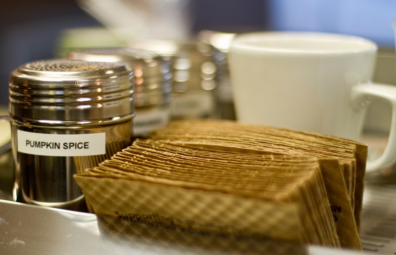 a tray with napkins and several bottles of spices for coffee
