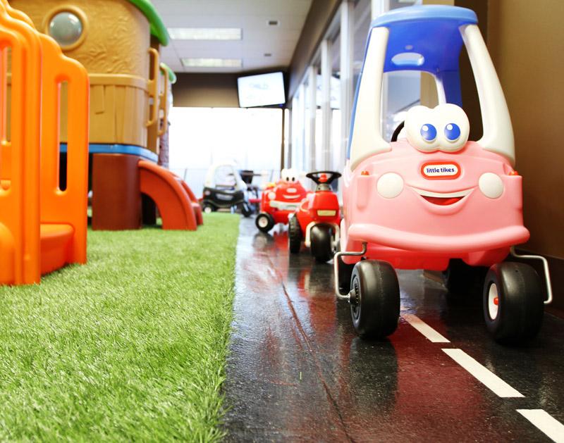 3 toy cars lined up near a big green mat